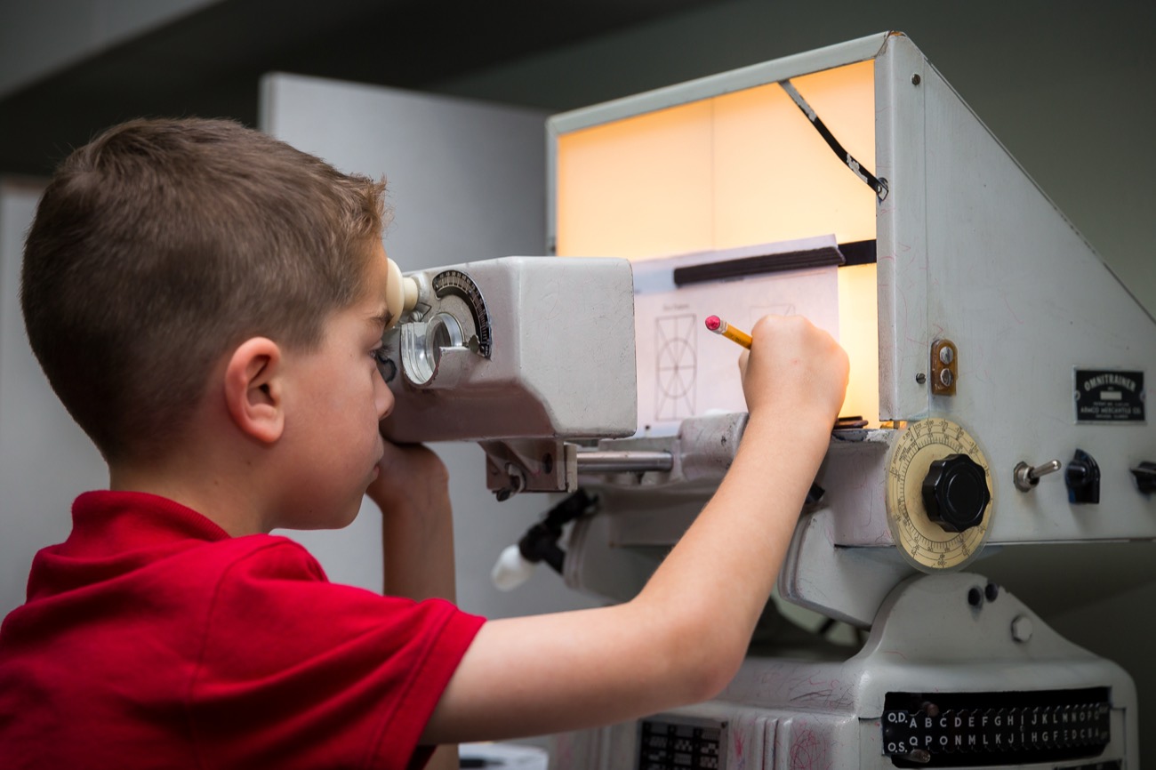 A young patient tracing at a classic therapy instrument